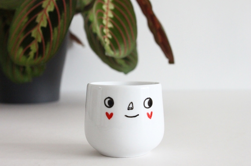 Maranta prayer plant and hand illustrated egg cup with face drawing.